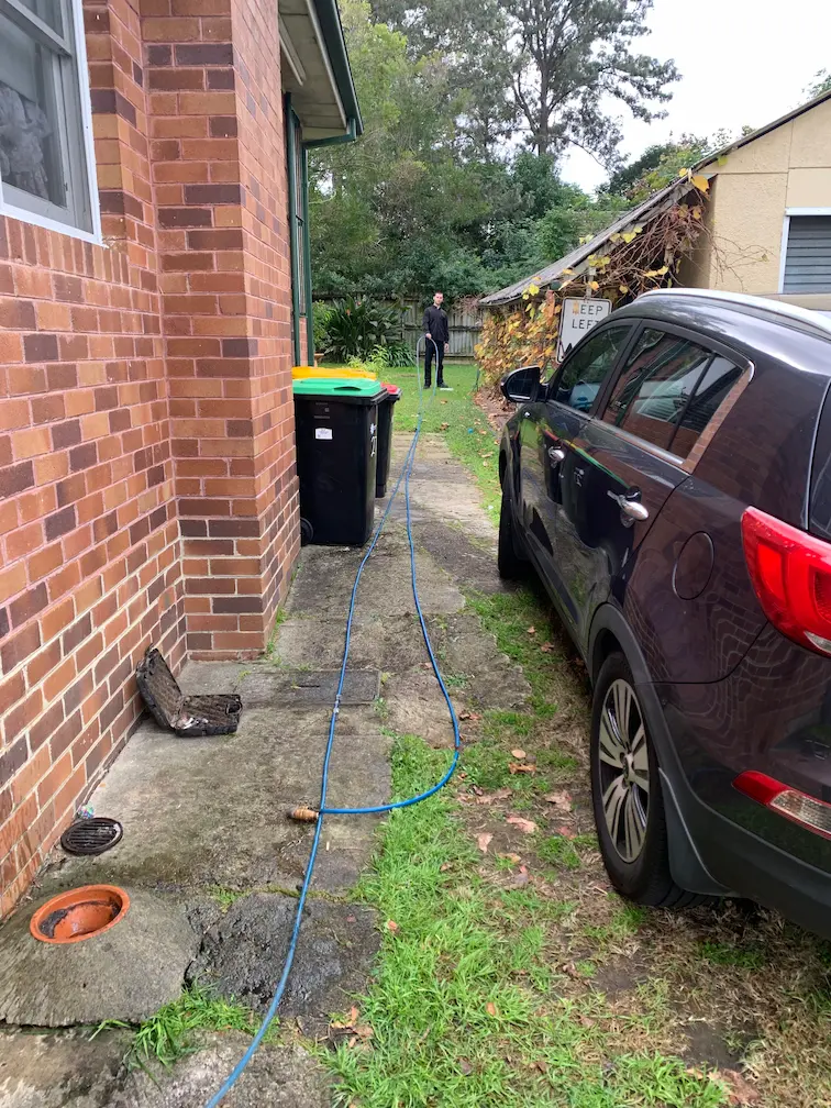 Professional plumber using high-pressure jetter to clear a blocked drain in Marayong.